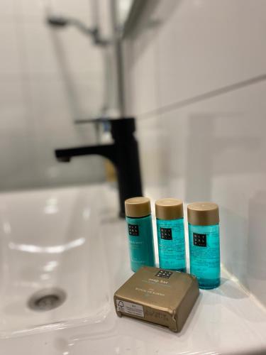 two bottles ofodorizers sitting next to a sink at Appartement Dishoek in Koudekerke