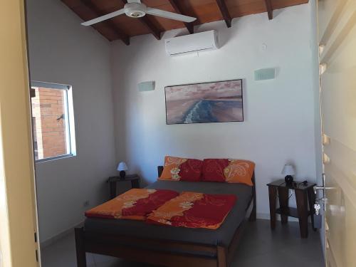 a bedroom with a bed and a ceiling fan at Casita-Azul in Ypacarai