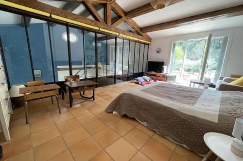 une chambre avec un grand lit et un salon dans l'établissement Magnifique villa familiale tout confort à 10 min d'Aix-en-Provence, à Ventabren