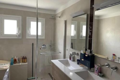 La salle de bains est pourvue d'une douche et de 2 lavabos blancs. dans l'établissement Magnifique villa familiale tout confort à 10 min d'Aix-en-Provence, à Ventabren