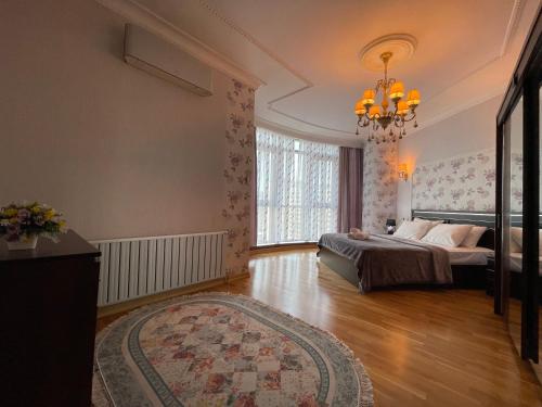 a bedroom with a bed and a large window at Megafun Sea View in Baku