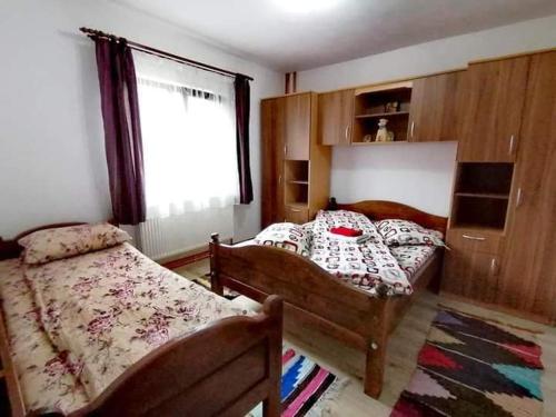1 dormitorio con 2 camas y ventana en Casa Ianis, en Arieşeni