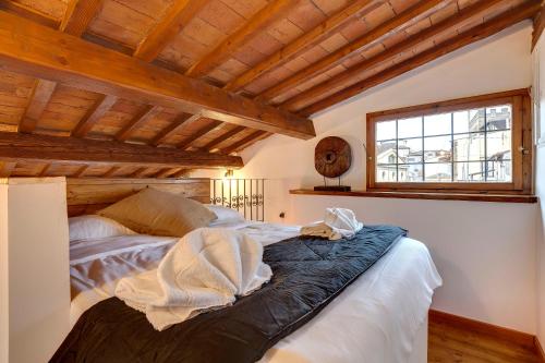 Ce lit se trouve dans un dortoir doté d'un plafond en bois. dans l'établissement Mamo Florence - Opera - Sinfonia - Minuetto - Melody Apartments, à Florence