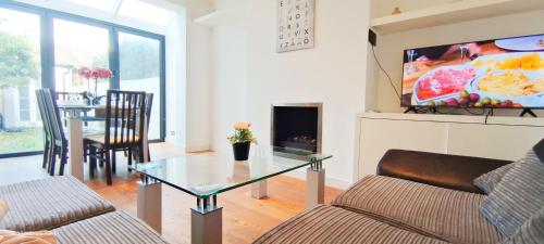 a living room with a couch and a glass table at Park View Garden in London