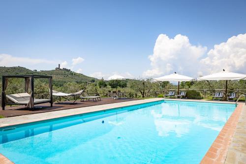 a large swimming pool with chairs and umbrellas at Agriturismo LaPievuccia in Castiglion Fiorentino
