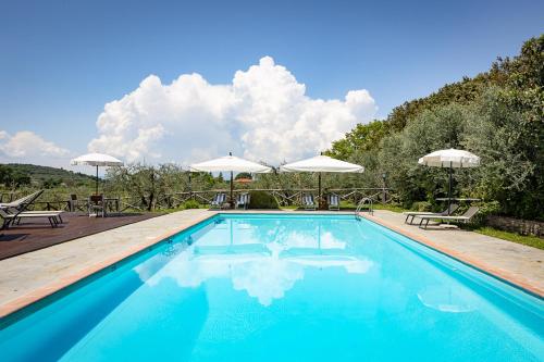 einen Pool mit Stühlen und Sonnenschirmen auf einem Gehöft in der Unterkunft Agriturismo LaPievuccia in Castiglion Fiorentino