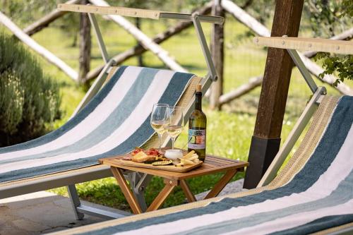 a table with a bottle of wine and wine glasses at Agriturismo LaPievuccia in Castiglion Fiorentino