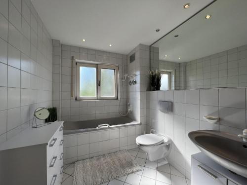 ein Badezimmer mit einem Waschbecken, einem WC und einer Badewanne in der Unterkunft Seeperle in Uhldingen-Mühlhofen