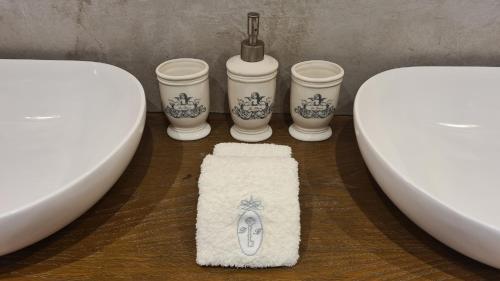a bathroom with a toilet and three cups and a rug at Domaine de la Blonnerie in Feings