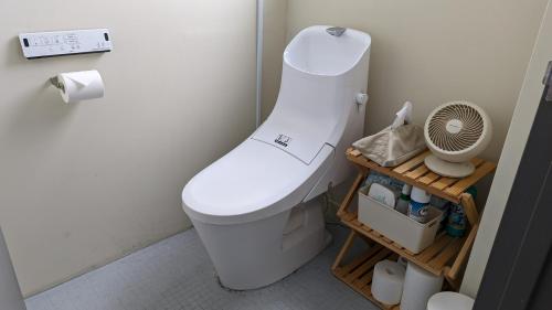 um WC branco numa casa de banho com uma ventoinha em La Union Twin room with share bath room - Vacation STAY 31448v em Fukushima