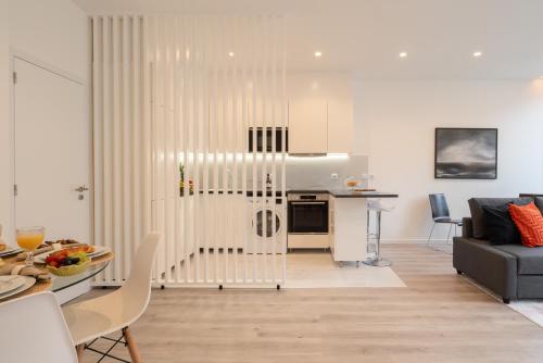 un salon avec une cuisine et un salon avec une table dans l'établissement Trendy Spacious Flats - Matosinhos, à Matosinhos