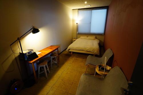 a small room with a bed and a desk and chairs at La Union Double room with share bath room - Vacation STAY 31425v in Fukushima