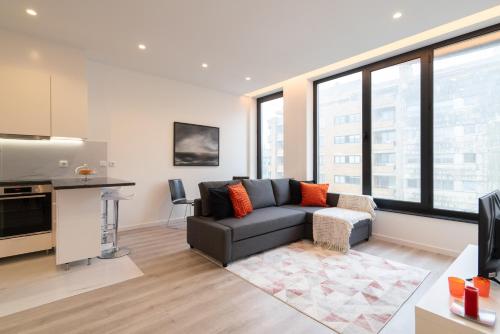 a living room with a couch and some windows at Trendy Spacious Flats - Matosinhos in Matosinhos