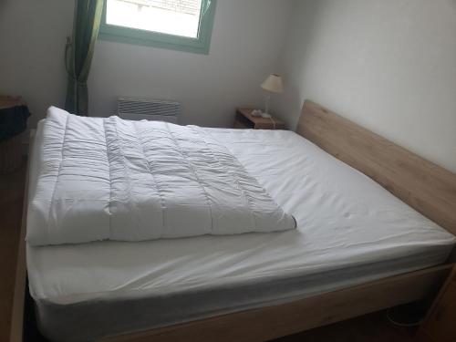 - un lit avec des draps blancs et une fenêtre dans une chambre dans l'établissement Appartement T2 Cabine Proche Plage avec Balcon et Parking Privé - FR-1-482-110, à Fort-Mahon-Plage