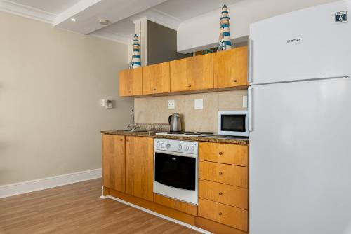 a kitchen with a stove and a refrigerator at Caprice Court 6 in Cape Town