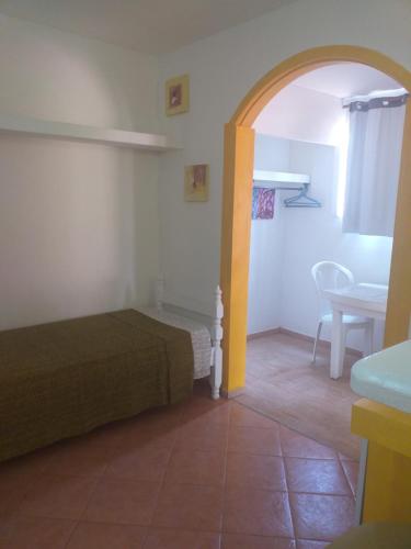 ein Schlafzimmer mit einem Bett und einem Tisch in einem Zimmer in der Unterkunft Pousada Vila Magiosa in Búzios