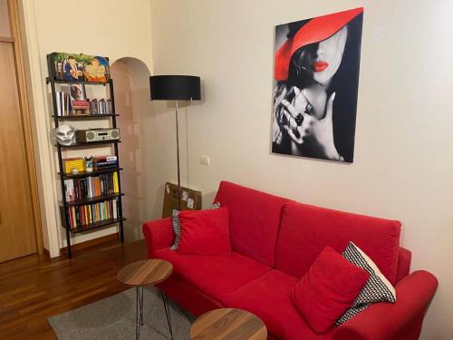 ein rotes Sofa im Wohnzimmer mit einem Gemälde in der Unterkunft Donna Ada al Duomo in Salerno