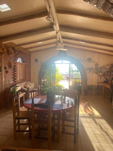 Casa Gutiérrez في Teotitlán del Valle: غرفة طعام مع طاولة وكراسي ونافذة