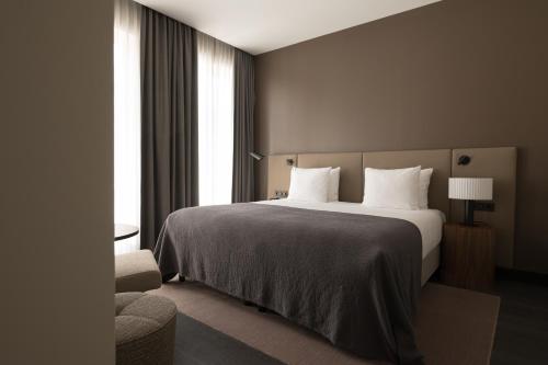 a hotel room with a large bed and a window at BEAUMONT Maastricht in Maastricht