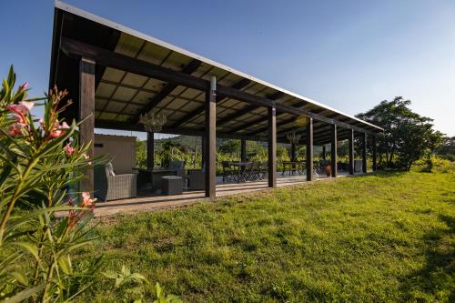 a pavilion with tables and chairs on a grass field at Agriturismo LaPievuccia in Castiglion Fiorentino