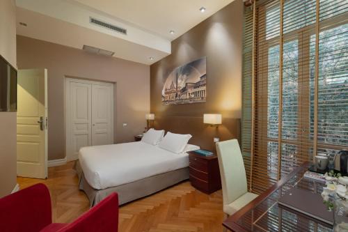 a bedroom with a bed and a desk and a window at Hotel Principe Torlonia in Rome