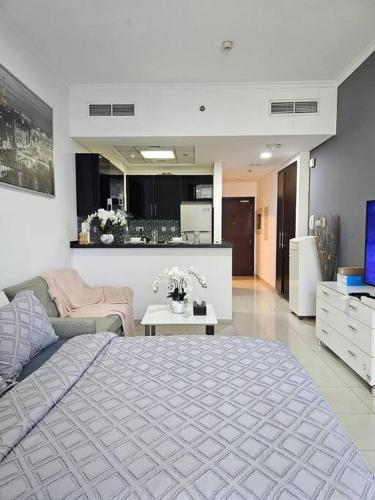a bedroom with a large bed and a living room at Luxury Botanica Studio Apartment 75 in Dubai