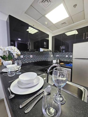 a kitchen with a table with plates and wine glasses at Luxury Botanica Studio Apartment 75 in Dubai
