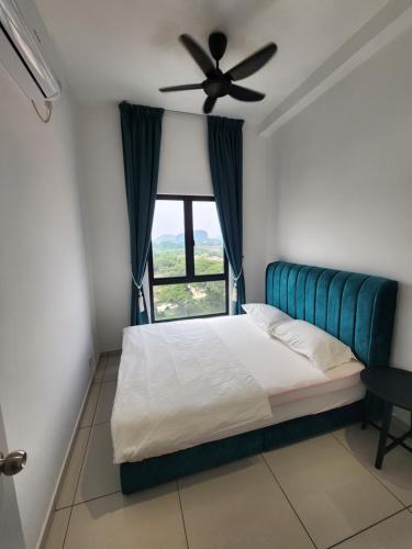 a bedroom with a bed with a ceiling fan and a window at Horizon Premium Suite - Ipoh in Ipoh
