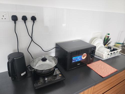 a toaster oven sitting on a counter next to a microwave at Horizon Premium Suite - Ipoh in Ipoh