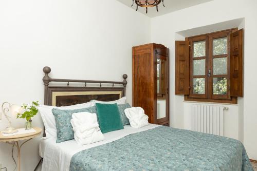 a bedroom with a large bed with blue and white pillows at Agriturismo LaPievuccia in Castiglion Fiorentino