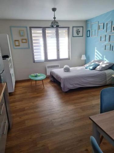 une chambre avec un lit et une table dedans dans l'établissement Cadre vert - Saint-Julien-les-villas, à Saint-Julien-les-Villas