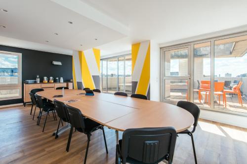 a meeting room with a long table and chairs at Aparthotel Adagio Access Paris La Villette in Paris