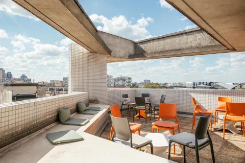 a balcony with chairs and tables on a roof at Aparthotel Adagio Access Paris La Villette in Paris
