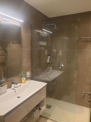 a bathroom with a shower and a sink and a mirror at Beautiful Golf & Sea View in As Sīfah