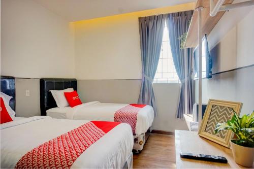 een hotelkamer met 2 bedden en een raam bij SUPER OYO 93064 Alhesa Residence in Medan