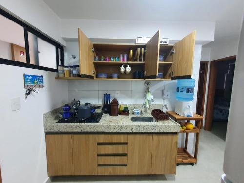 cocina con armarios de madera y encimera en Vila Atlântida 207B en Luis Correia