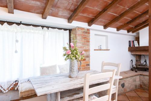 a dining room table with a vase of flowers on it at Agriturismo LaPievuccia in Castiglion Fiorentino