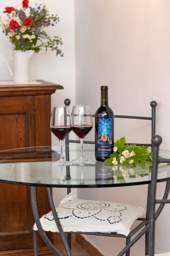 a bottle of wine and two glasses on a table at Agriturismo LaPievuccia in Castiglion Fiorentino