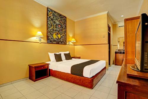 a hotel room with a bed and a tv at Super OYO Collection O 91081 New Arena Hotel in Kuta