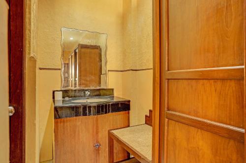 baño con lavabo y espejo junto a una puerta en Super OYO Collection O 91081 New Arena Hotel en Kuta
