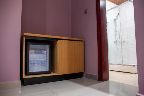 - une télévision dans un coin de pièce dans l'établissement HOTEL MICKEL, à Douala