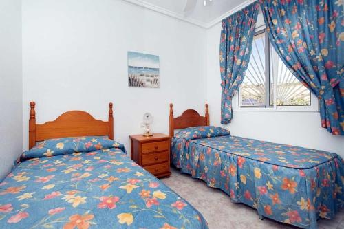 ein Schlafzimmer mit zwei Betten und einem Fenster in der Unterkunft CH Marquesa Golf (Ciudad Quesada) in Rojales
