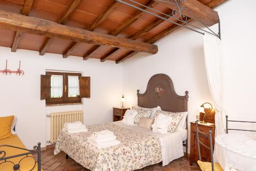 a bedroom with a bed with white walls and wooden ceilings at Agriturismo LaPievuccia in Castiglion Fiorentino