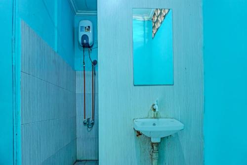 y baño con lavabo y espejo. en OYO 91731 Home Stay Elis Cateliya Syariah, en Karawang