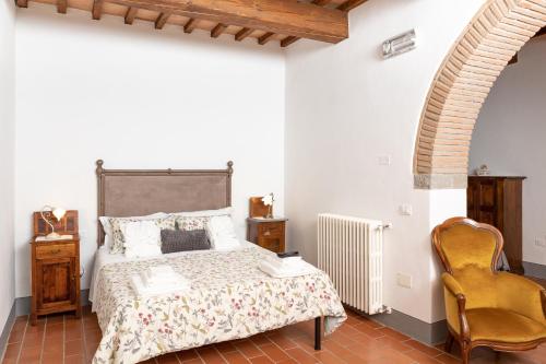 a bedroom with a bed and a chair at Agriturismo LaPievuccia in Castiglion Fiorentino