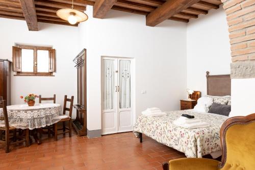 a bedroom with a bed and a table and a table and chairs at Agriturismo LaPievuccia in Castiglion Fiorentino