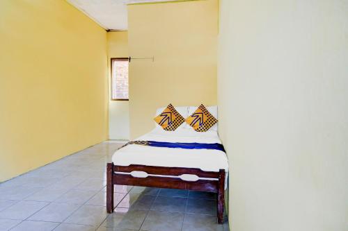 - un petit lit dans une chambre aux murs jaunes dans l'établissement OYO Life 90701 Kost Syariah Deris, à Sumedang