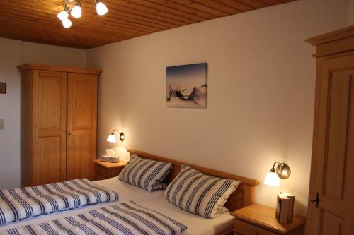 a bedroom with two beds and two lights on the wall at Bernerhof Ferienwohnungen Schmuck in Teisendorf