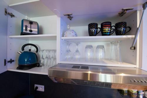 une cuisine avec un comptoir et des étagères dans l'établissement Le petit Marcel - Saint-Julien-les-Villas, à Saint-Julien-les-Villas