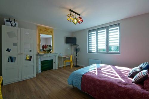 ein Schlafzimmer mit einem Bett und einem Schreibtisch. in der Unterkunft Le petit Marcel - Saint-Julien-les-Villas in Saint-Julien-les-Villas
